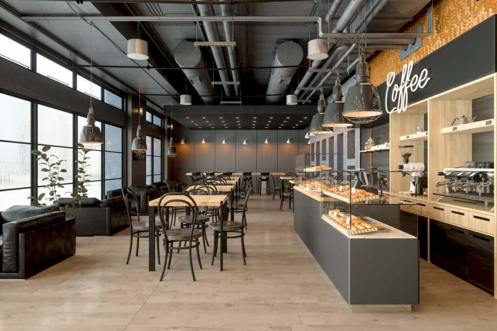 NORMAL-iStockPhoto 1024px-1428594094 Empty Coffee Shop Interior With Wooden Tables, Coffee Maker, Pastries And Pendant Lights